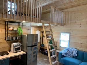 a kitchen with a refrigerator and a ladder in a room at Equuleus Lofted Kabin in Fenelon Falls