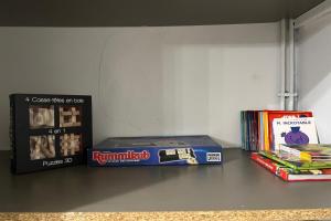 une étagère avec des jeux et des livres dans l'établissement Le joli Velten - Wifi - Métro, à Marseille