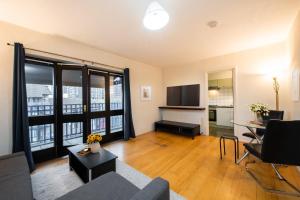 een woonkamer met een bank en een tv bij Amazing 2Bed in Canary Wharf in Londen