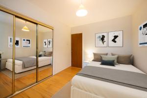 een slaapkamer met 2 bedden en een spiegel bij Amazing 2Bed in Canary Wharf in Londen