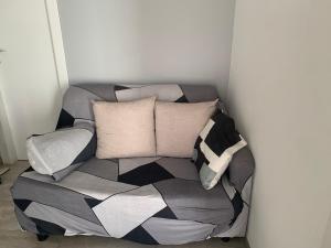 un sofá sentado en una esquina con almohadas en Camera con bagno privato, en Ragalna