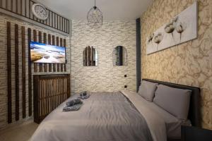 ein Schlafzimmer mit einem großen Bett und einer Uhr an der Wand in der Unterkunft GpxClr GuestSuiteNo2 in Larisa