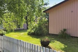 un patio con una valla y una maceta de flores en The Pink House en Halmstad