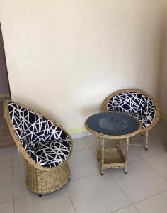 VILLA ESPERANZA KITUI في Kitui: كرسيين الخوص وطاولة في الغرفة