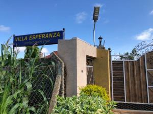 een huis met een blauw bord erop bij VILLA ESPERANZA KITUI in Kitui