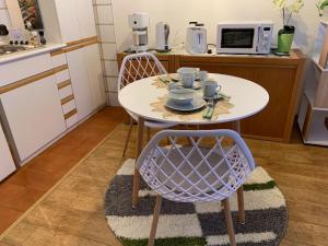 una cucina con tavolo, 2 sedie e forno a microonde di Ferienwohnung Casa Bella Verde a Lesa