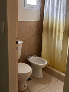 a bathroom with a toilet and a sink at La Casa de Emma in General Roca