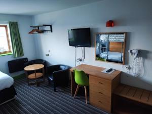 a hotel room with a desk and a mirror at Happy Guests Lodge in Lower Whitley