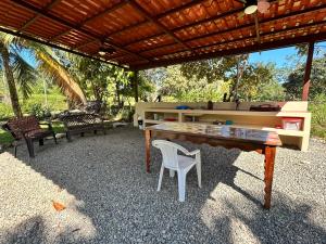 una mesa de ping pong y sillas bajo una pérgola en Orange Cabina, en Puerto Jiménez