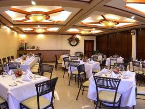 a banquet hall with white tables and chairs at Camiguin Highland Resort in Mambajao