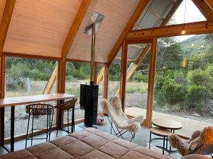 Habitación con sofá, mesa y sillas. en El Diucón Eco Lodge en Villa Meliquina