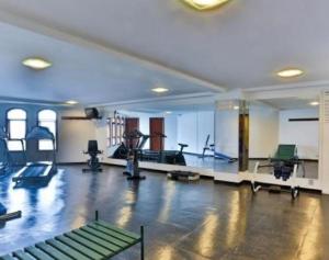 een fitnessruimte met diverse fitnessapparatuur in een grote ruimte bij Suíte no castelo flat no Home Green Home in Campos do Jordão