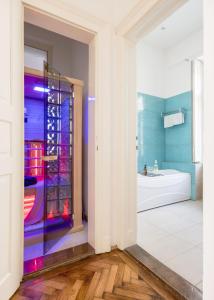 a bathroom with a tub and a glass shower door at Wellness Retreat with Sauna & Jacuzzi - 1 min to Opera in Budapest