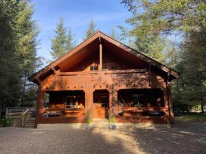 a log cabin in the middle of a forest at Large Luxury Log Cabin Getaway in Ballyconnell