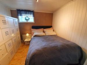 1 dormitorio con 1 cama en una habitación pequeña en Sentral leilighet, nært tog, buss, sykehus og byen, en Bodø