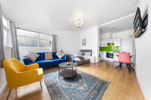 een woonkamer met een blauwe bank en een tafel bij Spacious Studio High Street Location in Londen
