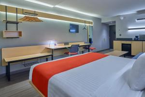 a hotel room with a bed and a desk at City Express by Marriott Tijuana Otay in Tijuana