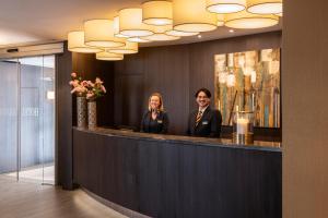 a man and a woman standing at a reception counter at Aragon House in Bruges