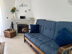 a blue couch in a living room with a fireplace at Dreams in Xisto in Piódão