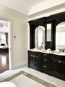 un bagno con due lavandini e due specchi di Vihome520-Beautiful house near North York Center a Toronto