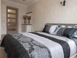sypialnia z czarno-białym łóżkiem z poduszkami w obiekcie Tbilisi-apartment w mieście Tbilisi City