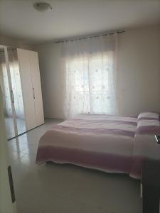 um quarto com uma cama grande e uma janela em Vista Monte Retreat em Reggio di Calabria