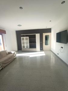 een woonkamer met een bank en een flatscreen-tv bij Vista Monte Retreat in Reggio di Calabria
