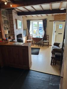 Annie’s Cottage في Llanrhaeadr-ym-Mochnant: غرفة معيشة مع مطبخ وغرفة طعام