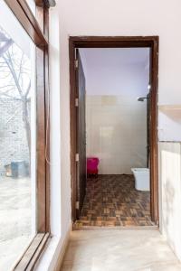 an open door to a bathroom with a toilet at MountArawaliHills in Bhundsi