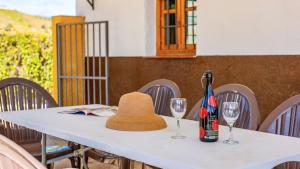 a table with a hat and two wine glasses on it at Casa Rocio Almachar by Ruralidays in Almáchar