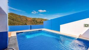 Casa Rocio Almachar by Ruralidays في Almáchar: مسبح باللونين الأزرق والأبيض مع جبل في الخلفية