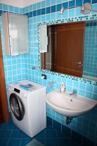 een badkamer met een wasmachine en een wastafel bij Elegante appartamento trilocale in Milaan