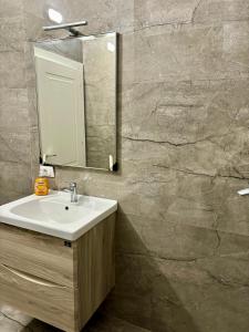 une salle de bain avec un lavabo et un miroir dans l'établissement Sea Breeze Apartment by Z, à Durrës