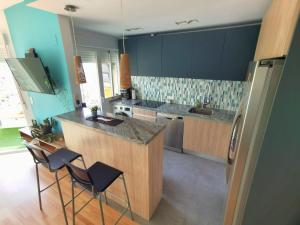 een keuken met blauwe muren en een aanrecht en stoelen bij Miramar 22 in Almuñécar