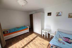 ein Schlafzimmer mit 2 Betten und einem Tisch darin in der Unterkunft Ferienwohnung in Savognin in Savognin