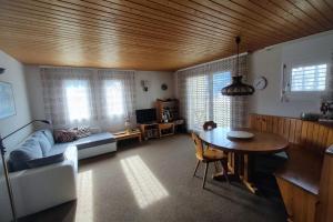 ein Wohnzimmer mit einem Tisch und einem Sofa sowie ein Esszimmer in der Unterkunft Ferienwohnung in Savognin in Savognin