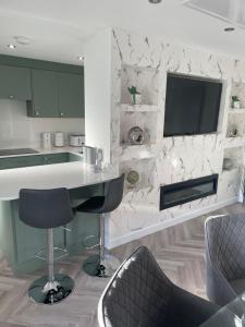 a kitchen with a counter and a tv on a wall at Savannah Lodge in Wyke Regis