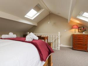 a bedroom with a large white bed and skylights at Riverdale House in Skipton