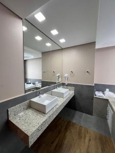 a bathroom with two sinks and a large mirror at Nayru Hotel in Toledo