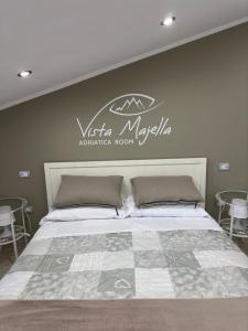 um quarto com uma cama com uma placa na parede em Vista Majella em Paglieta