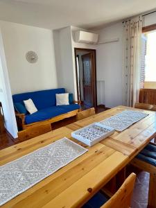 uma sala de estar com um sofá azul e uma mesa de madeira em TALAhome27 em Alghero