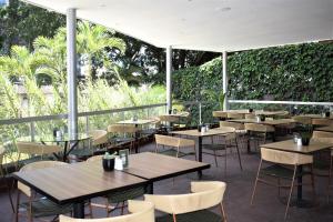 un restaurante con mesas, sillas y plantas en Hotel Estelar Blue, en Medellín