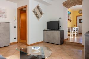 a living room with a tv and a glass table at Casa La Corte in centro, self check in in Clusone