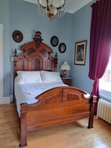 sypialnia z dużym drewnianym łóżkiem w pokoju w obiekcie Gîte au Charme Victorien w mieście Beauceville