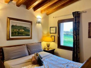 Schlafzimmer mit einem Bett und einem Fenster in der Unterkunft Casale Collecchio Siena in Siena