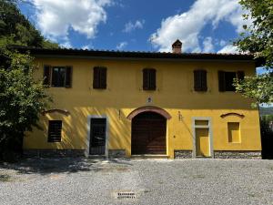 een geel gebouw met een grote deur en ramen bij A.G. Rooms in casa colonica in Vaiano