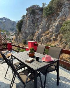 einen Holztisch mit einem rosa Hut auf dem Balkon in der Unterkunft Casa Di Rosse in Symi