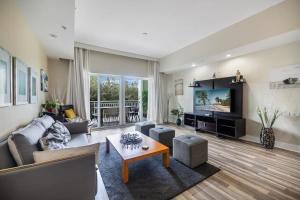 a large living room with a couch and a tv at Stylish 2 Story residence on the golf - by Viac in Miami