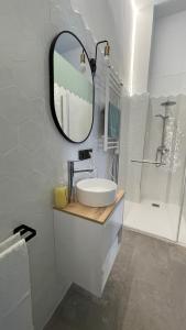 a white bathroom with a sink and a mirror at Origen Valladolid in Valladolid
