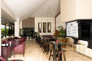 a restaurant with couches and tables and chairs at Smart Cancun the Urban Oasis in Cancún
